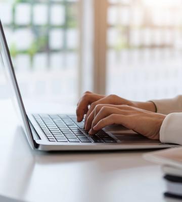 Woman types on a laptop computer