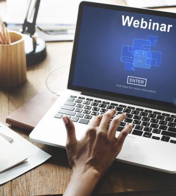 hand typing on an open laptop that says Webinar