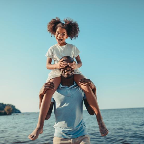 A father and daughter by the ocean.