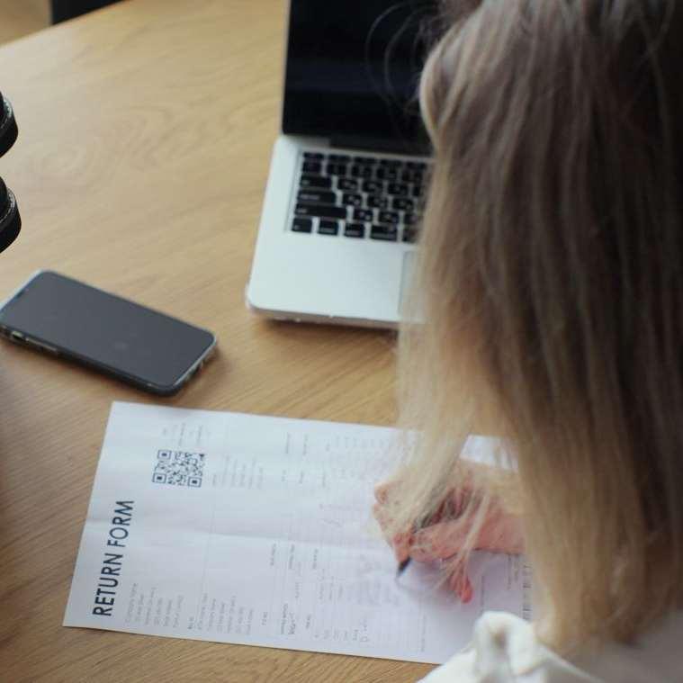 A person filling out a returns form.